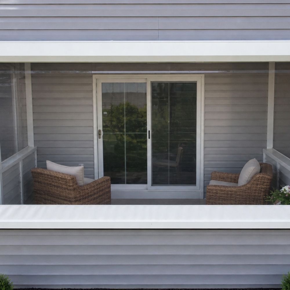 Retractable clear vinyl enclosure surrounding an outdoor patio seating area for weather protection